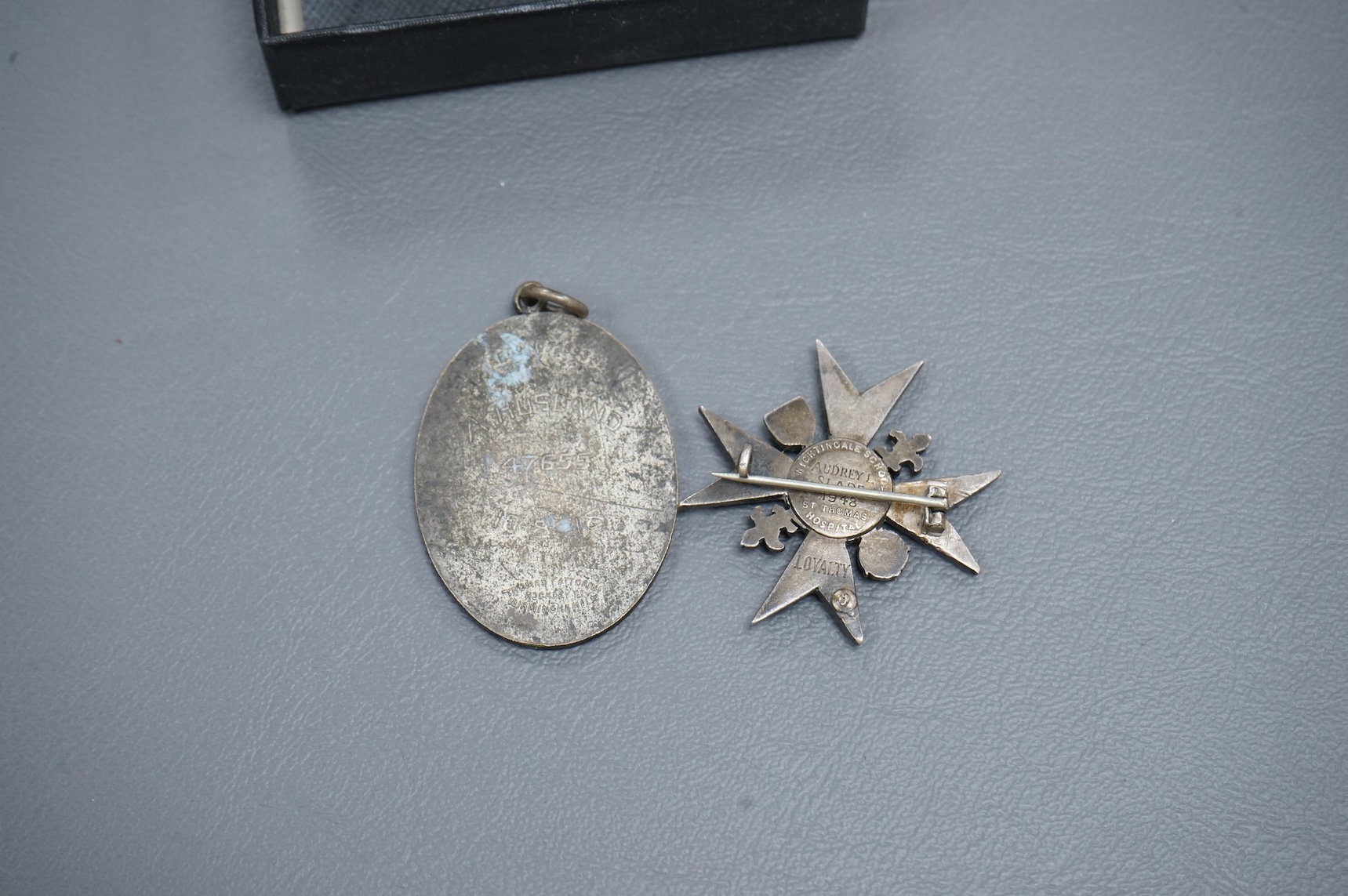 A Nightingale School enamelled ‘Loyalty’ badge, engraved to Audrey Slade, 1948 and a Certified Midwife medallion